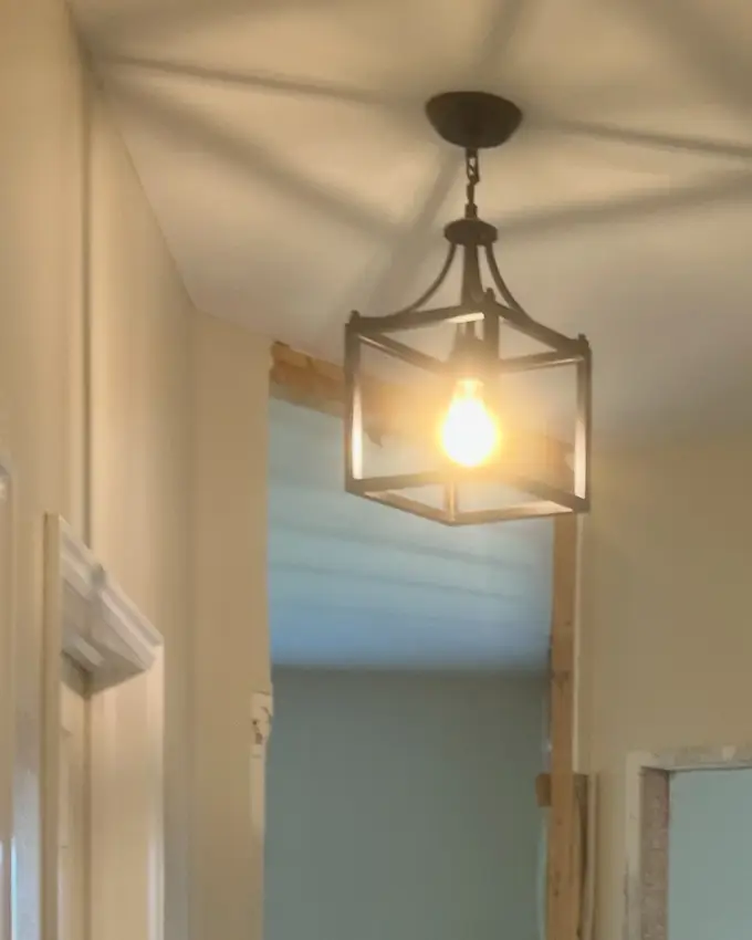A hallway mid-remodel with a new door opening framed and headed, casing not yet run