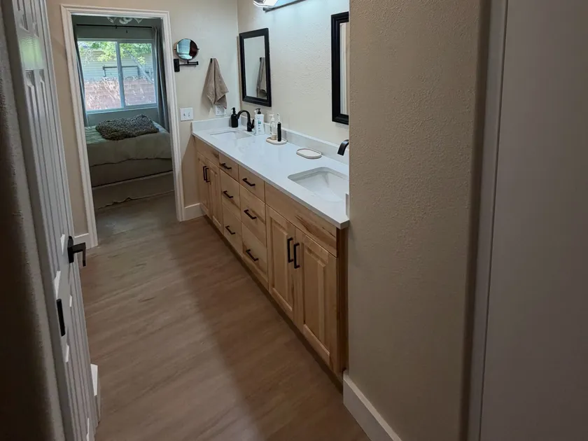 The finished master bathroom with a lengthened double vanity and new flooring