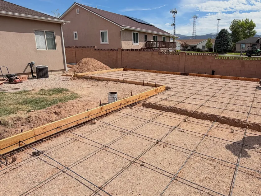 A formed garage slab with a full grid of reinforcing steel tied out across compacted ground